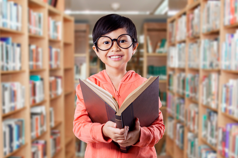 Happy Elementary School Student Reads Book